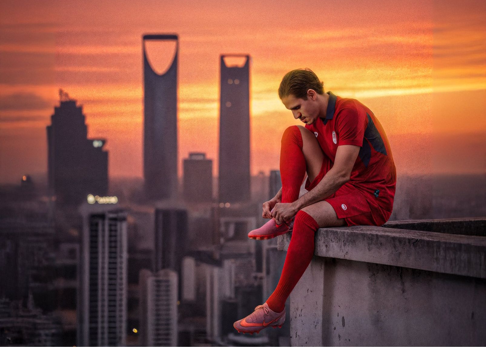 यथार्थवादी चित्रण या अमूर्तन? DAMAC आधिकारिक पोस्टर: खिलाड़ी अपने जूते के फीते बाँधने के लिए छत के किनारे पर बैठते हैं